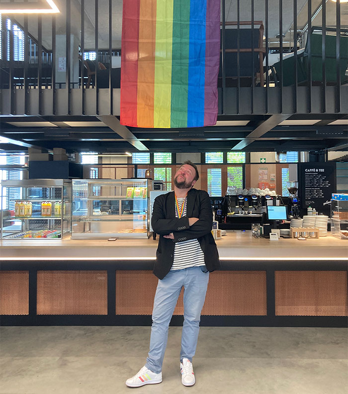 Lutz Staacke standing below a pride flag